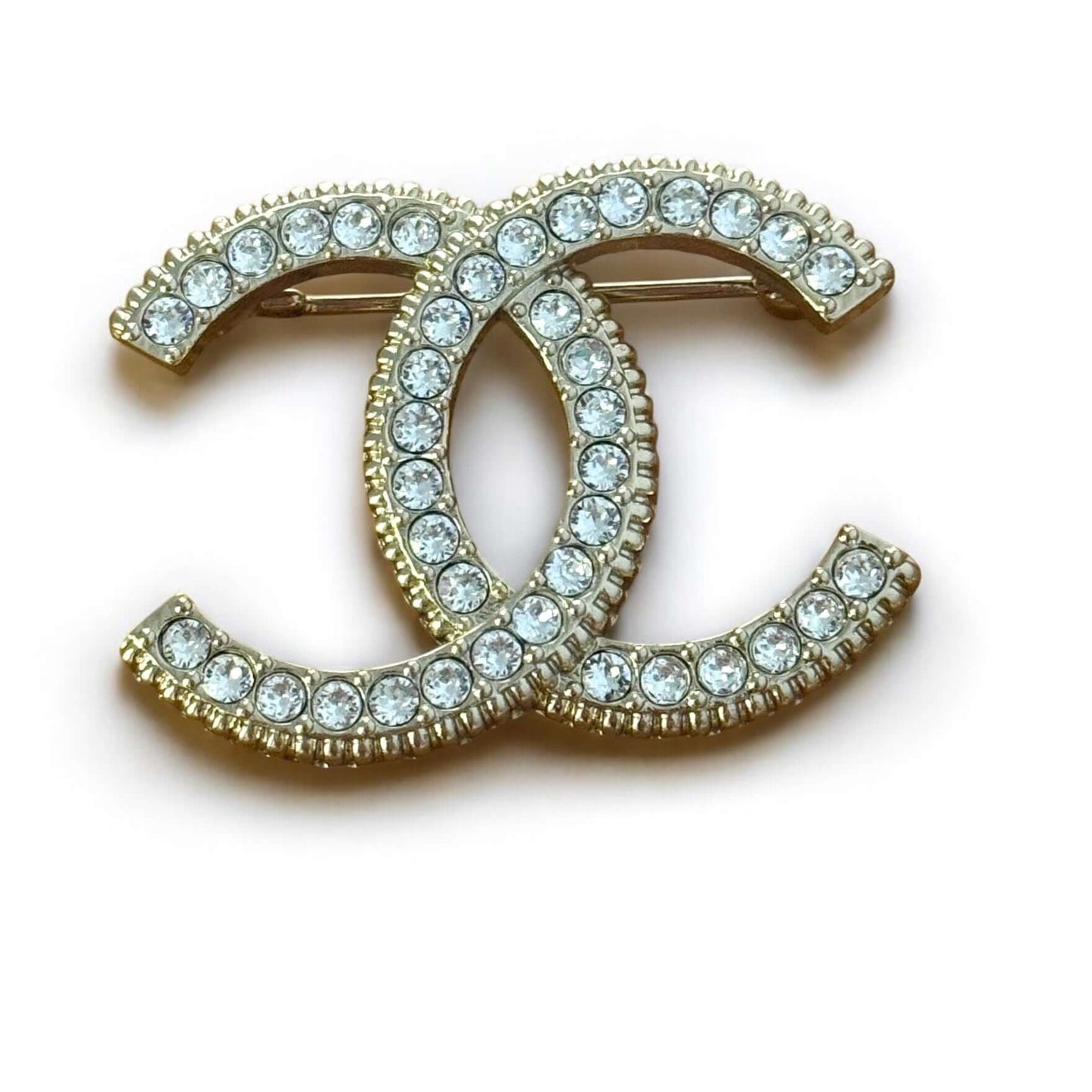 Stunning CHANEL Lighter Gold CC brooch adorned with clear crystals, perfect for year-round style, day or night.