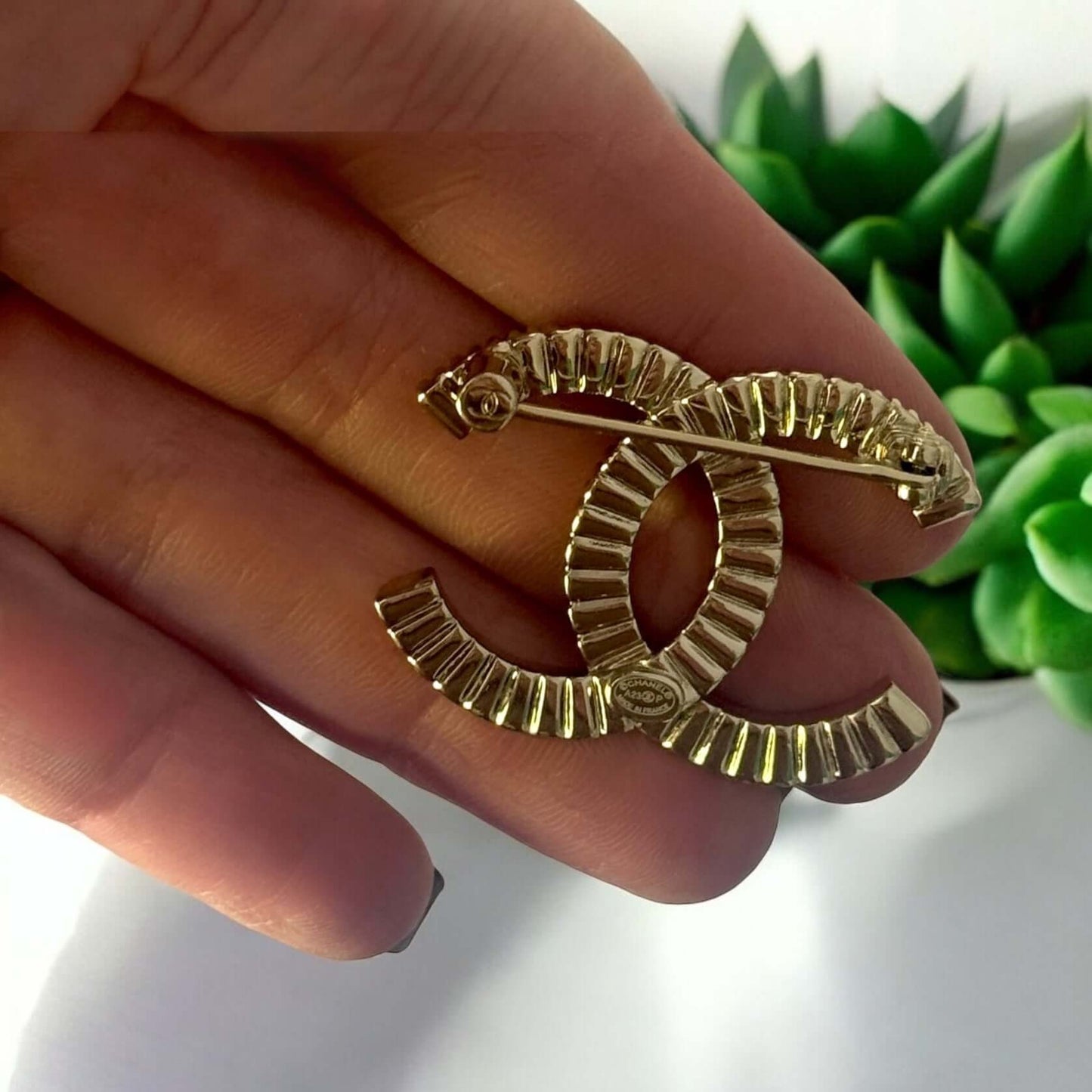 Stunning CHANEL Lighter Gold CC Brooch with crystal accents, perfect for year-round style, ideal for day or night.