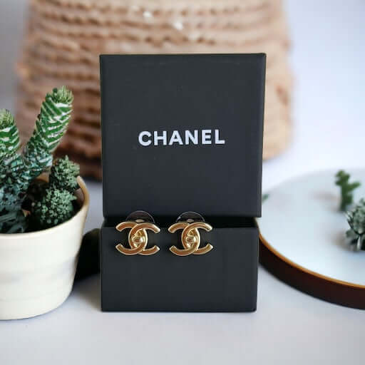 Chanel Gold Double C Lock Post EarringsIndulge in sophistication with our Chanel Gold Double C Lock Post Earrings. Crafted in 14K gold tone, these iconic and elegant earrings are the epitome of luxury. The double C lock style, made in Italy, adds a touch My Mama Found What