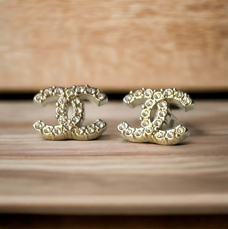 Chanel Lighter Gold Smaller Double C with round clear crystals earringsAccessorize with these lightweight Chanel Gold Double C earrings, featuring clear round crystals that add subtle sparkle to any outfit. Versatile for any occasion, these elegant earrin My Mama Found What