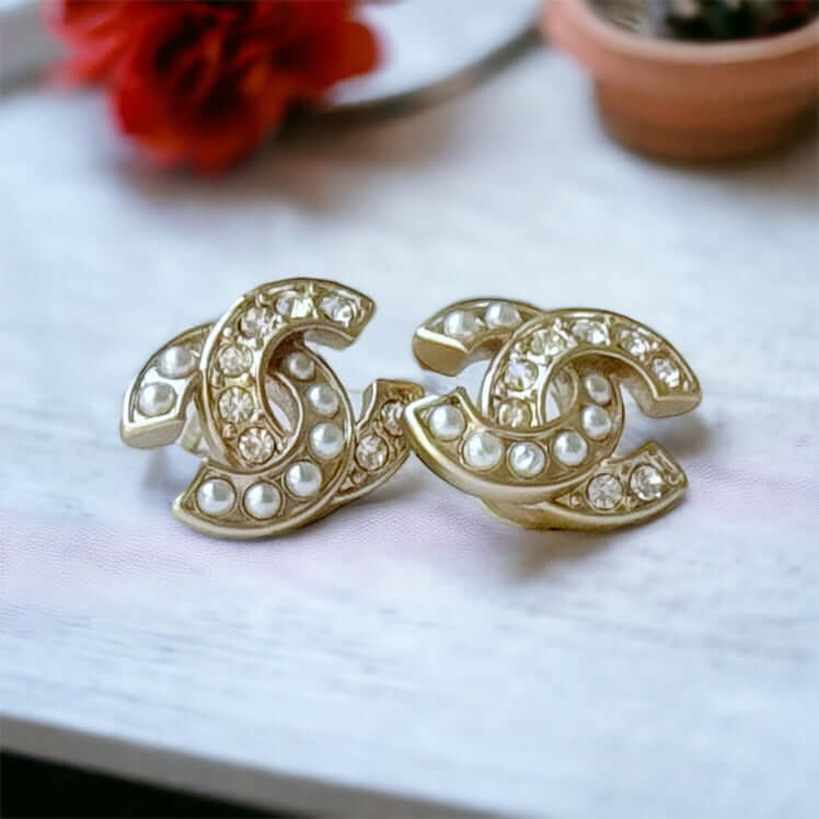 Chanel Gold Mini Double C with pearls & crystalsStylish and versatile, the Chanel Gold Double C Mini earrings add a touch of luxury to any outfit. With a mix of pearls and crystals, these earrings elevate your look for any occasion, day or night, all year My Mama Found What