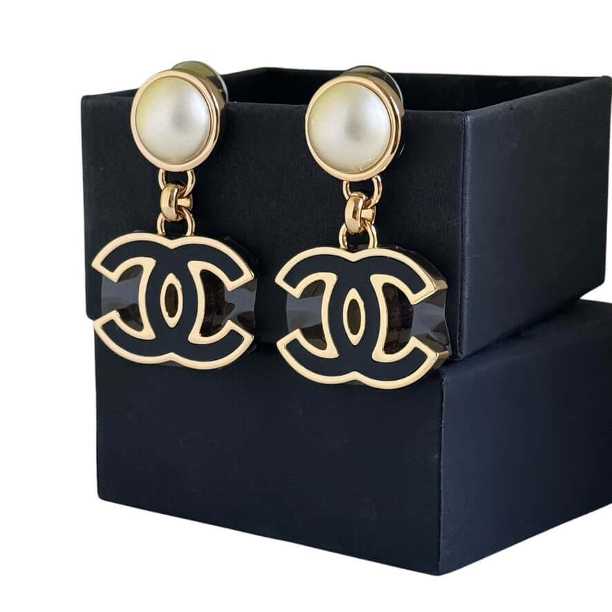 Authentic Chanel CC Gold White Black Dangle Earrings displayed in a gift box, pre-owned like new condition.