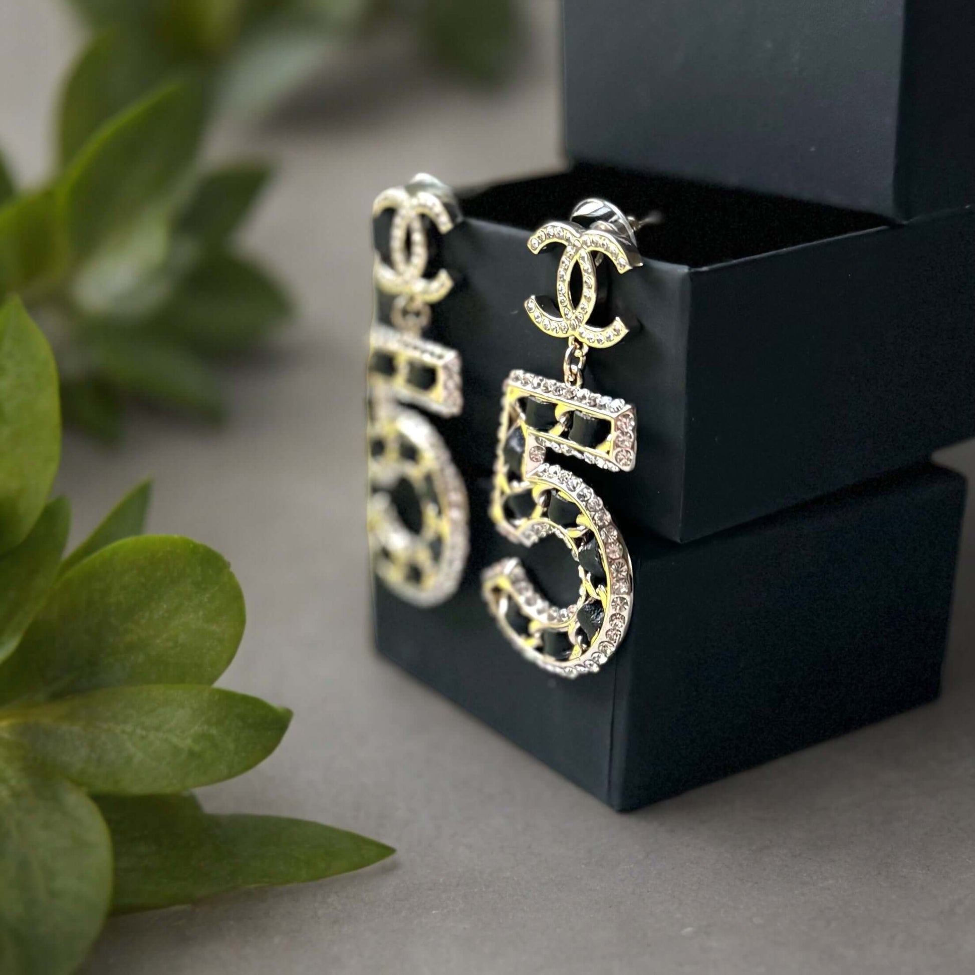 Chanel Gold Number 5 Big Dangle CC EarringsMake a statement with these iconic Chanel Gold Number 5 Big Dangle CC Earrings. The perfect addition to any outfit, these trendy and luxurious earrings feature gold plating, clear crystals, and a bold Chanel No.