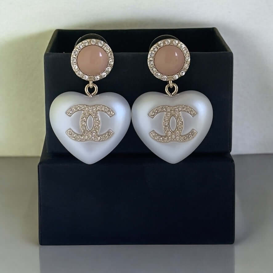 Rare Authentic Chanel CC Pink and White Heart Dangle Earrings Pre-Owned on display with elegant black box.