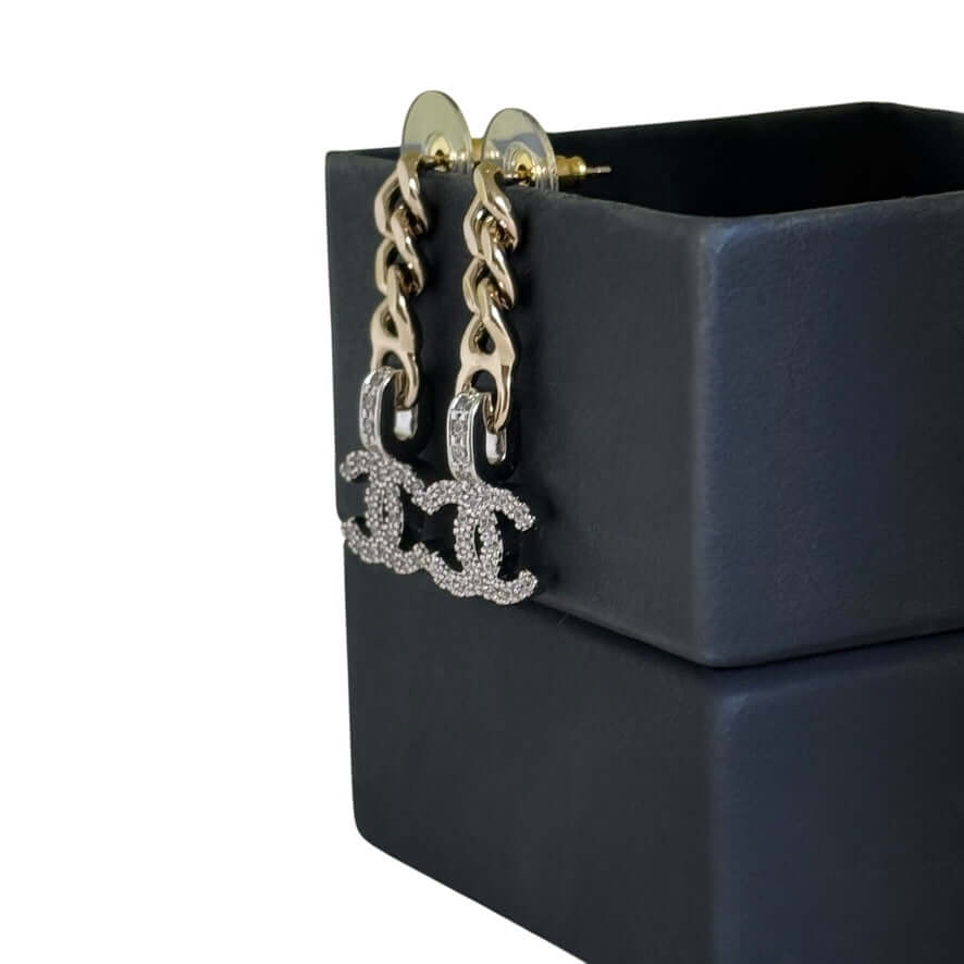 Pre-Owned Chanel CC Gold Chain Drop Earrings with Crystal Encrusted CC logo, elegantly displayed on a stylish black box.