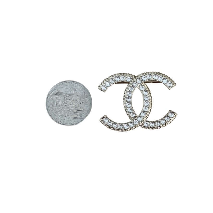 Authentic CHANEL CC Gold Brooch with crystals, showcased beside a quarter for size reference, like new pre-owned condition.