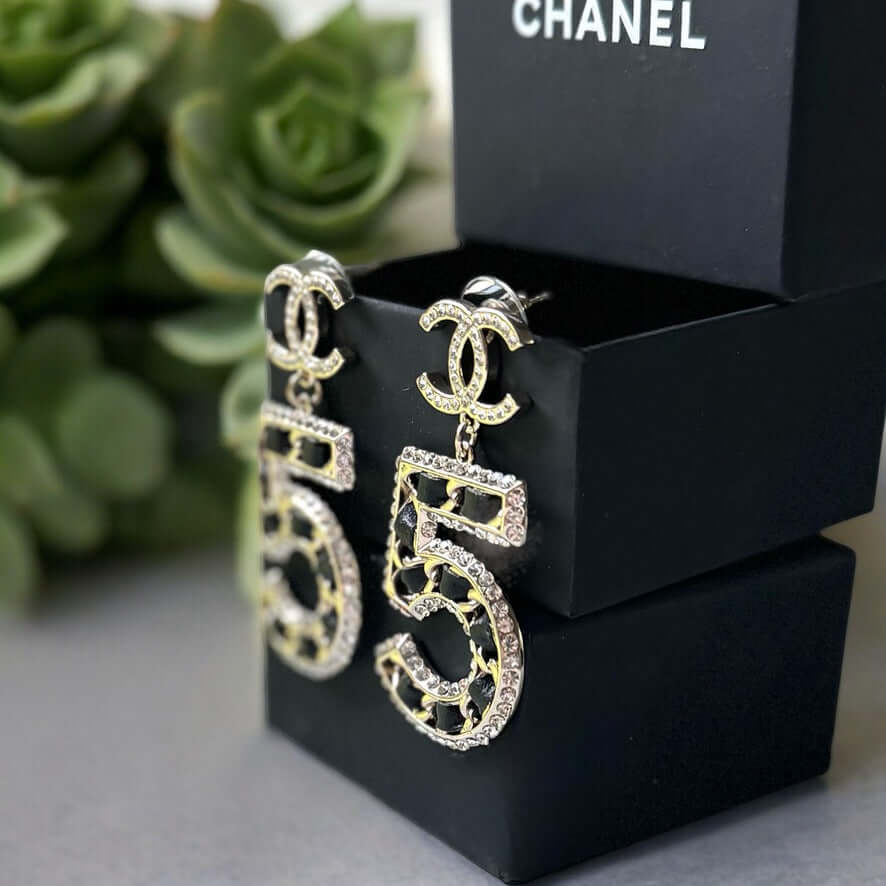 Chanel Gold Number 5 Big Dangle CC EarringsMake a statement with these iconic Chanel Gold Number 5 Big Dangle CC Earrings. The perfect addition to any outfit, these trendy and luxurious earrings feature gold plating, clear crystals, and a bold Chanel No.