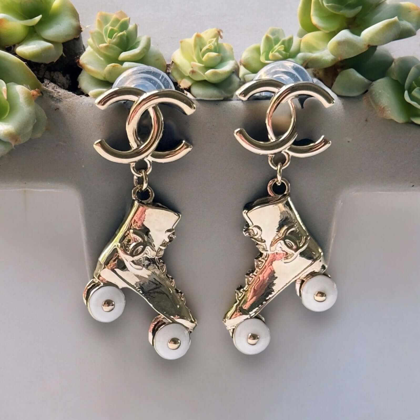 Chanel 14K Gold Tone Double C RARE Funky Rollar Skates Dangling EarringsRARE Hard To Find Unleash your fierce inner rockstar with these rare Chanel 14K Gold Tone Double C Dangling Earrings! Plated in 14k gold, the funky rollar skates with white enamel whe