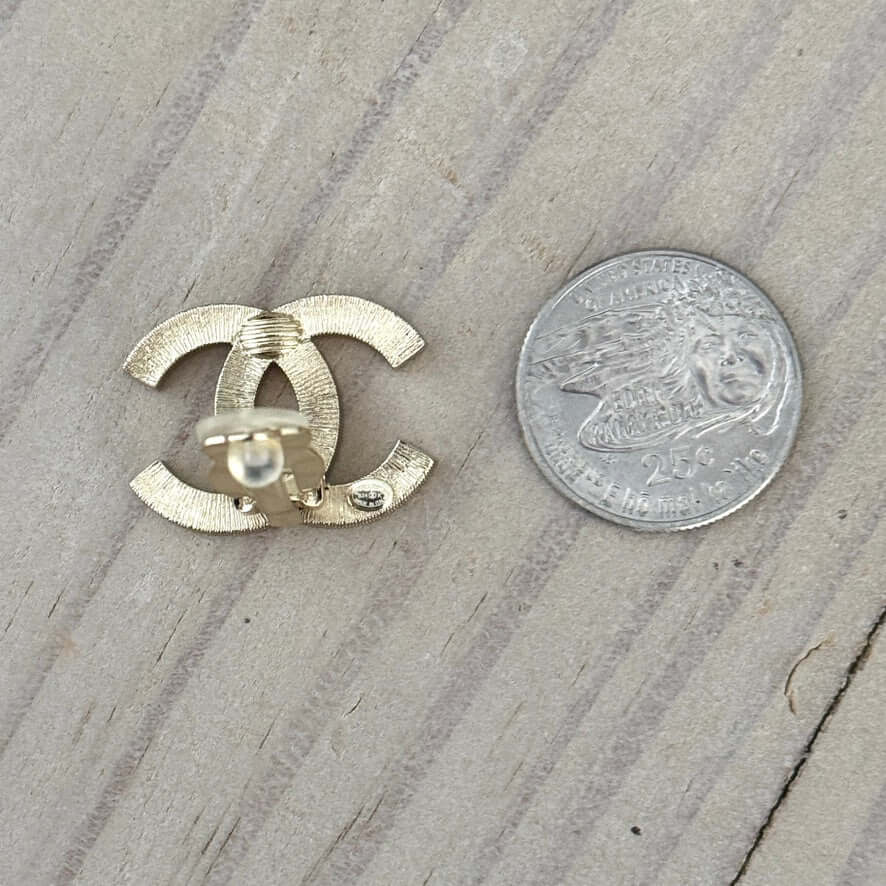 Authentic Chanel CC Lighter Gold Earrings next to a quarter for size comparison, excellent pre-owned condition.