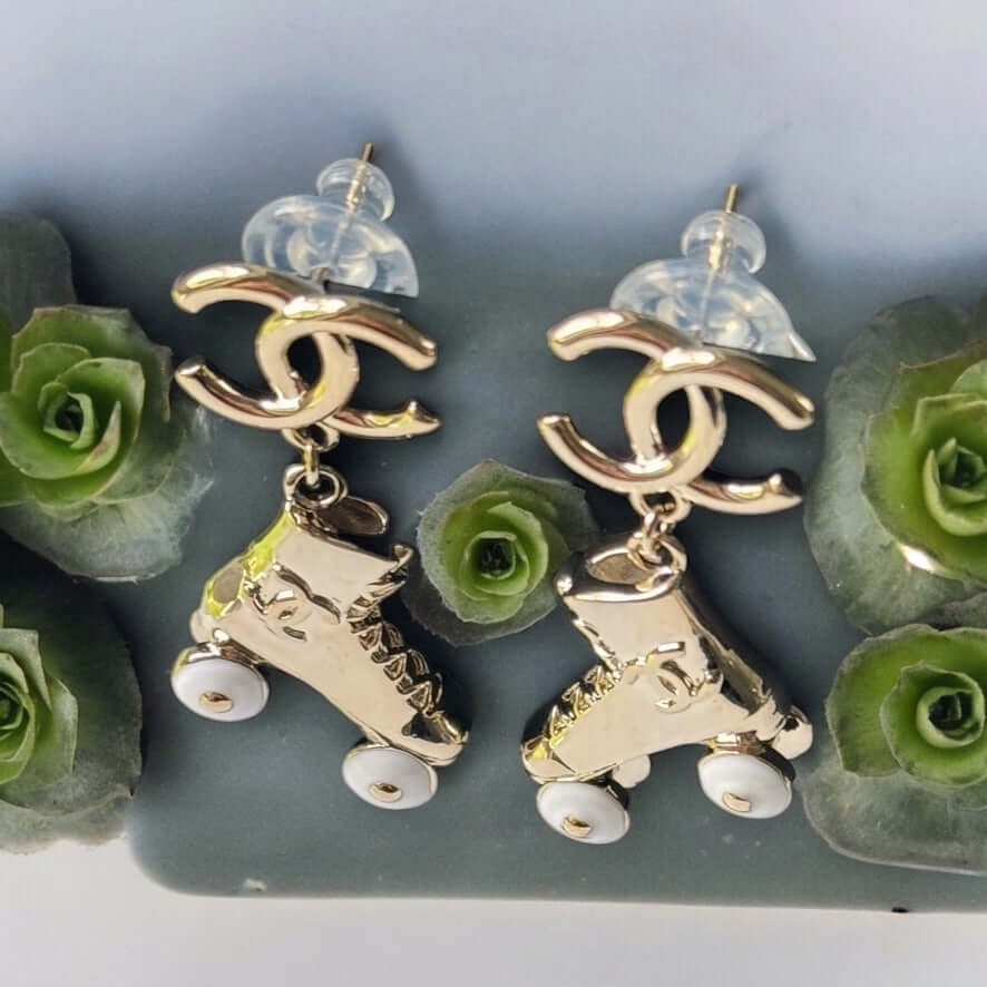 Chanel 14K Gold Tone Double C RARE Funky Rollar Skates Dangling EarringsRARE Hard To Find Unleash your fierce inner rockstar with these rare Chanel 14K Gold Tone Double C Dangling Earrings! Plated in 14k gold, the funky rollar skates with white enamel whe