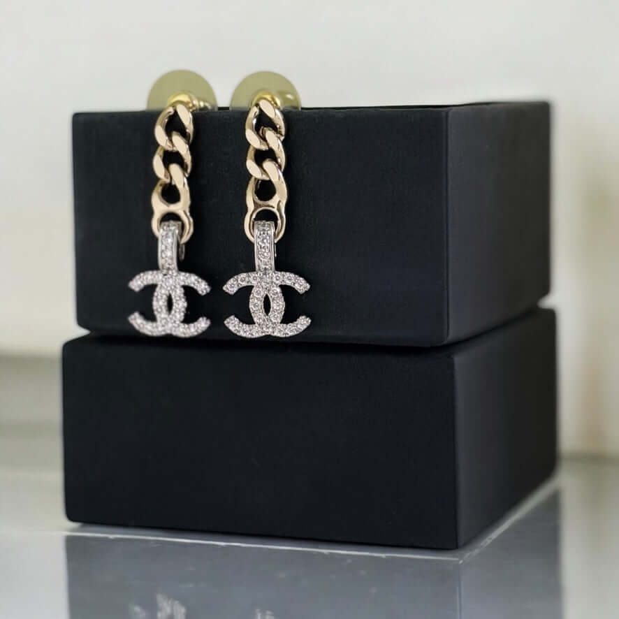 Pre-owned Chanel CC Gold Chain Drop Earrings with crystal accents, elegantly displayed on a black box.