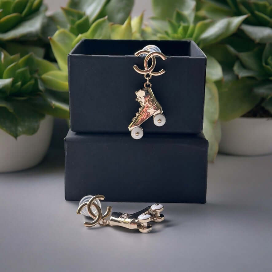 Chanel 14K Gold Tone Double C RARE Funky Rollar Skates Dangling EarringsRARE Hard To Find Unleash your fierce inner rockstar with these rare Chanel 14K Gold Tone Double C Dangling Earrings! Plated in 14k gold, the funky rollar skates with white enamel whe