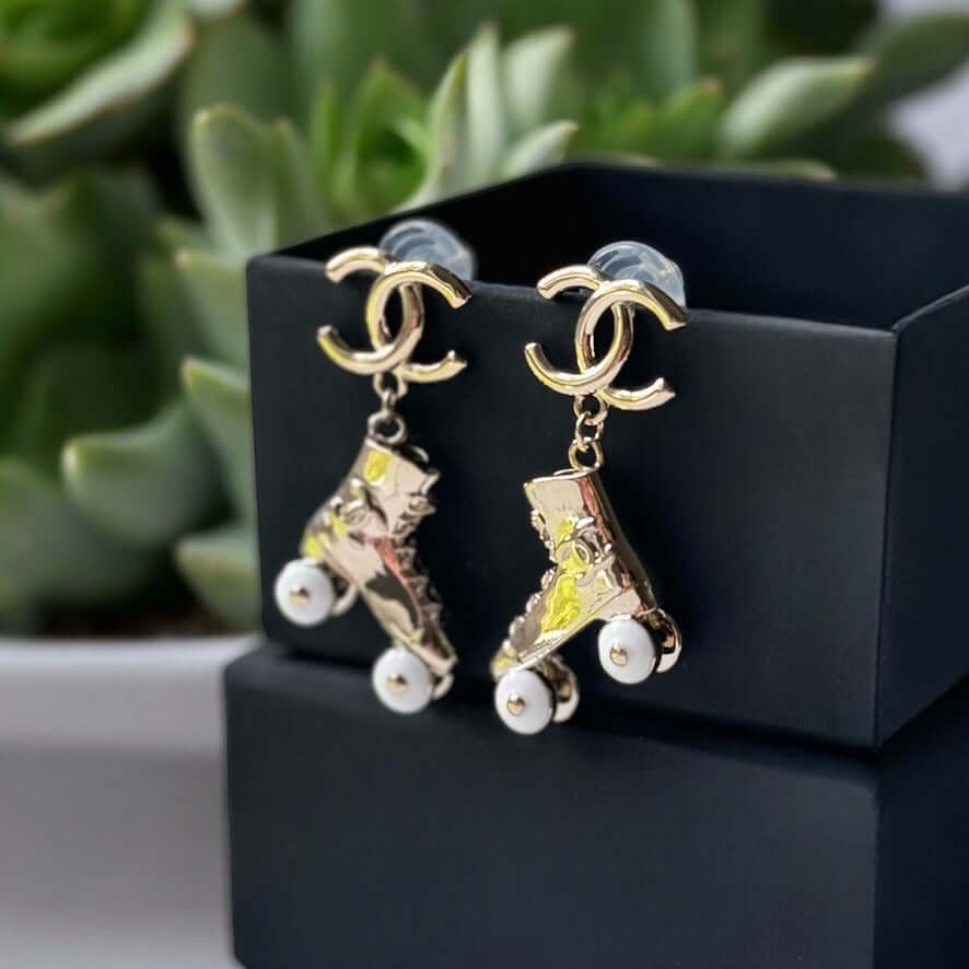 Chanel 14K Gold Tone Double C RARE Funky Rollar Skates Dangling EarringsRARE Hard To Find Unleash your fierce inner rockstar with these rare Chanel 14K Gold Tone Double C Dangling Earrings! Plated in 14k gold, the funky rollar skates with white enamel whe