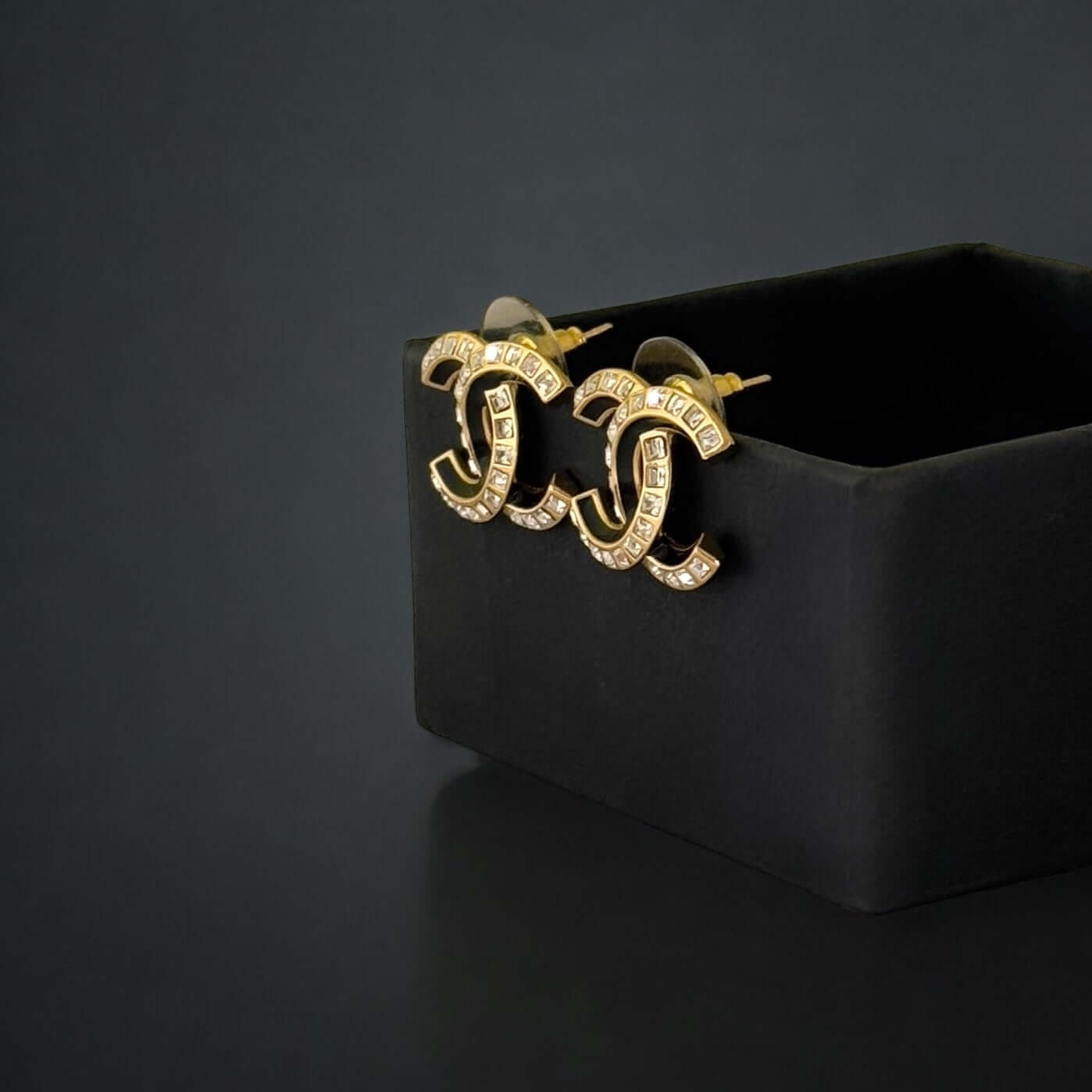 Pre-Owned Chanel Strass CC earrings with emerald cut crystals in black enamel, beautifully displayed in a black box.
