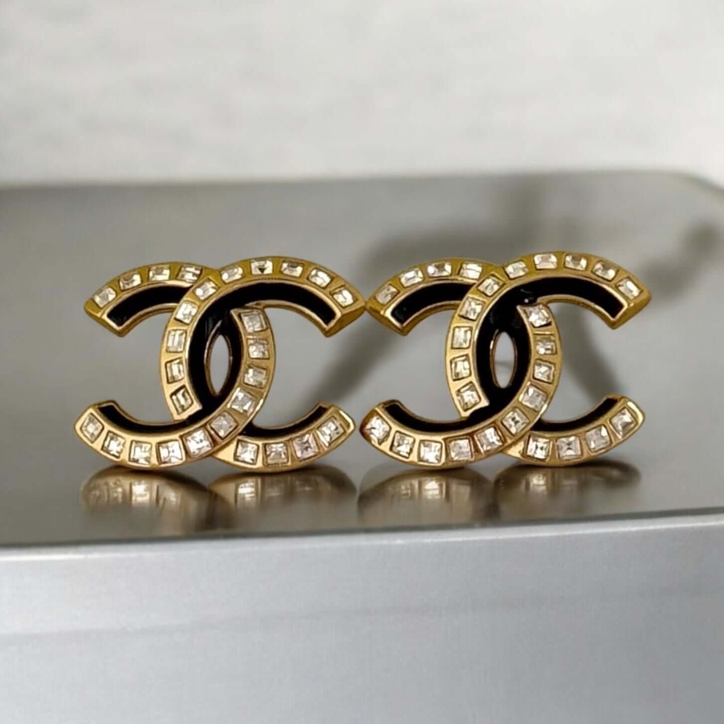 Pre-Owned Chanel Strass CC earrings with emerald cut crystals and black enamel for elegant style.