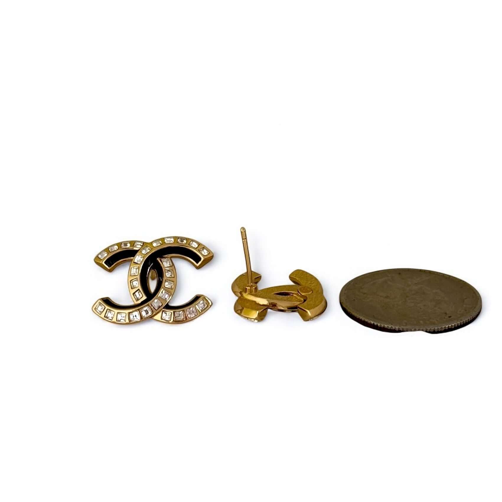 Pre-Owned Chanel Strass CC Emerald Cut Crystals earrings alongside a coin for size reference, showcasing luxury and elegance.