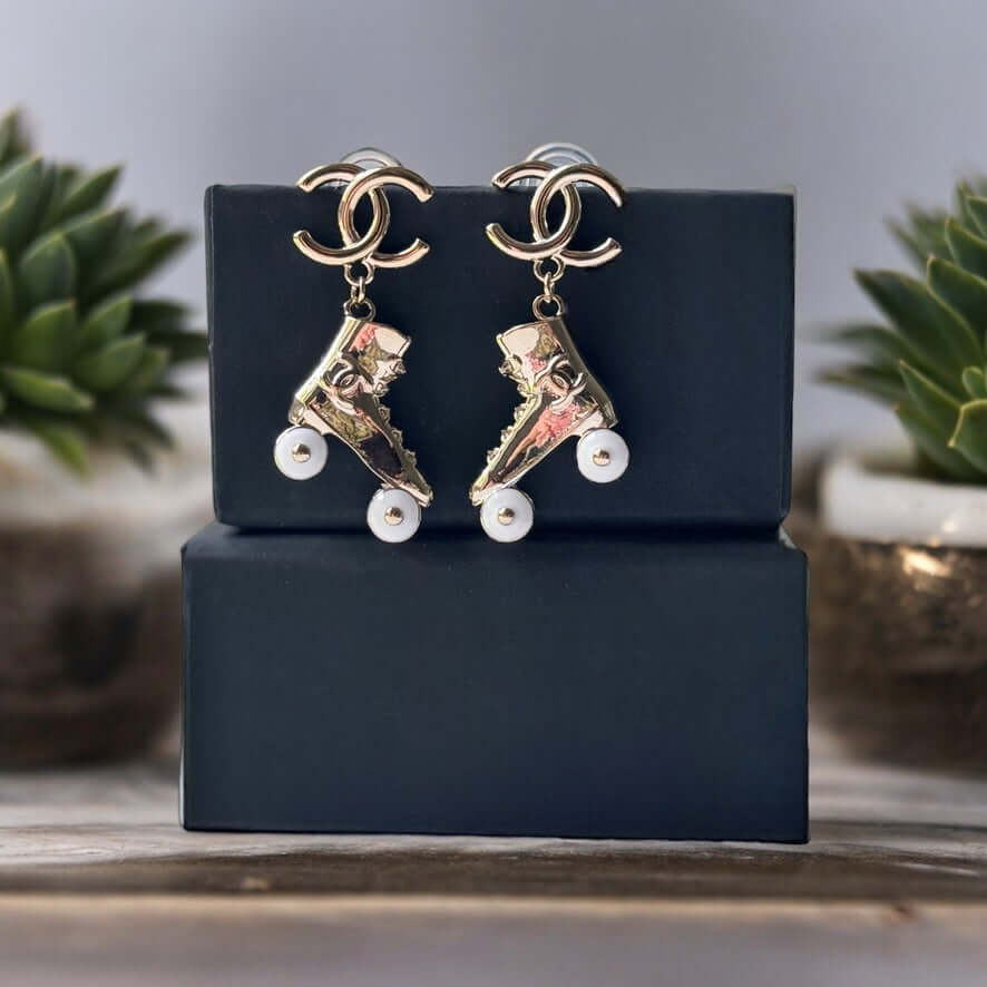 Chanel 14K Gold Tone Double C RARE Funky Rollar Skates Dangling EarringsRARE Hard To Find Unleash your fierce inner rockstar with these rare Chanel 14K Gold Tone Double C Dangling Earrings! Plated in 14k gold, the funky rollar skates with white enamel whe