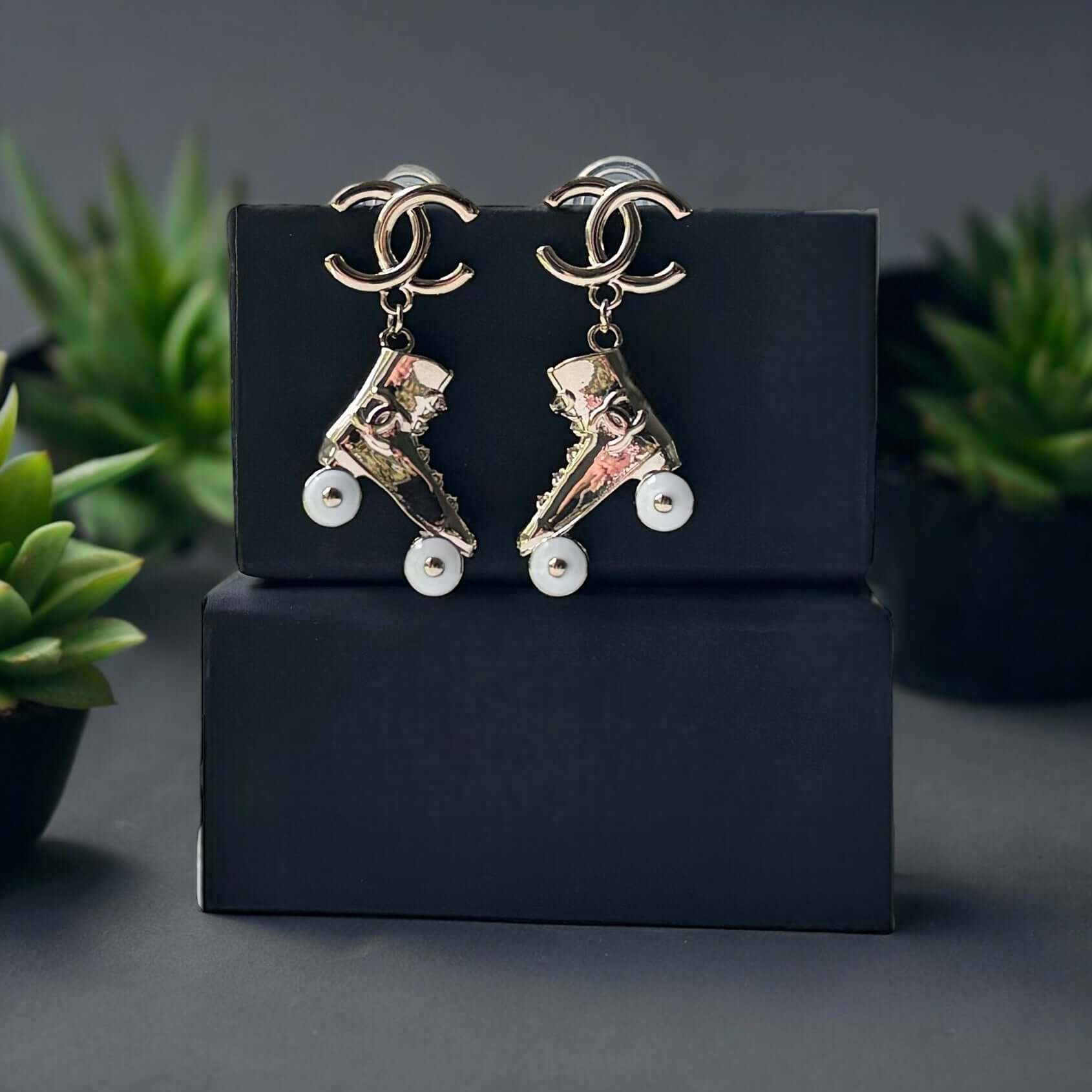 Chanel 14K Gold Tone Double C RARE Funky Rollar Skates Dangling EarringsRARE Hard To Find Unleash your fierce inner rockstar with these rare Chanel 14K Gold Tone Double C Dangling Earrings! Plated in 14k gold, the funky rollar skates with white enamel whe