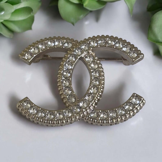 Stunning CHANEL Lighter Gold CC brooch with clear crystals, perfect for year-round style, ideal for day or night wear.