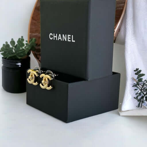 Chanel Gold Double C Lock Post EarringsIndulge in sophistication with our Chanel Gold Double C Lock Post Earrings. Crafted in 14K gold tone, these iconic and elegant earrings are the epitome of luxury. The double C lock style, made in Italy, adds a touch My Mama Found What 
