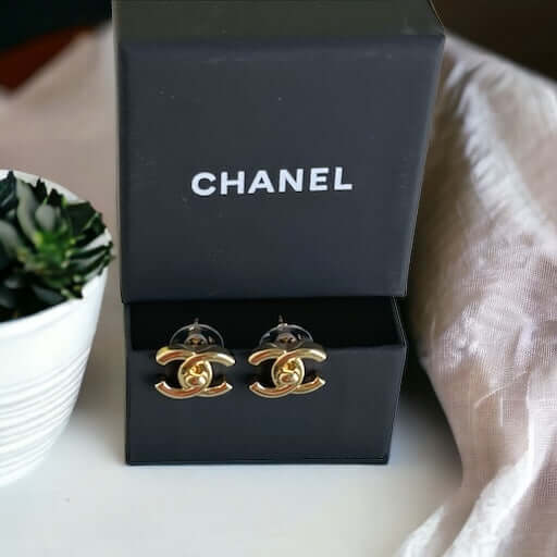 Chanel Gold Double C Lock Post EarringsIndulge in sophistication with our Chanel Gold Double C Lock Post Earrings. Crafted in 14K gold tone, these iconic and elegant earrings are the epitome of luxury. The double C lock style, made in Italy, adds a touch My Mama Found What 