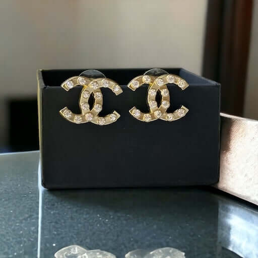 Chanel Gold Double C with raised clear Crystals Post EarringsThese Chanel Gold Double C earrings feature a rare design with clean style and a rock star appeal. The raised clear crystals add a touch of sparkle to these chic accessories. Crafted with gold, My Mama Found What 