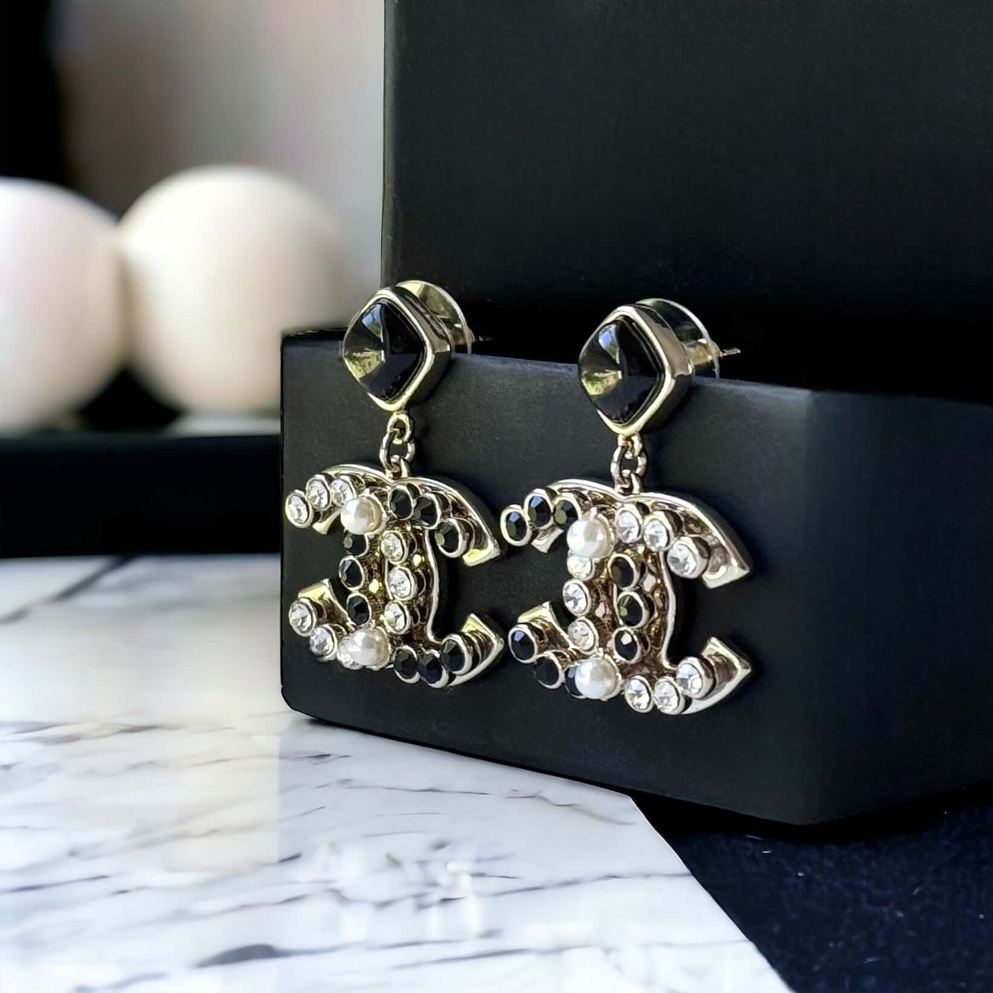 Chanel Gold Setting Double C Dangle Post EarringsAdd a touch of glamour to your outfit with these gold Chanel earrings featuring a double C design. The dangle style, adorned with faux pearls, clear crystals, and black stones, will catch everyone's eye wit My Mama Found What 
