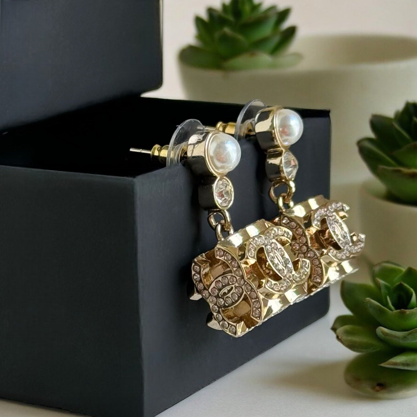 Chanel Gorgeous Rare Post Earrings with stunning Gold Double C encrusted clear crystalsThese Chanel earrings feature a stunning gold double C design, encrusted with clear crystals and a faux pearl center. The rare and like-new condition is reflected in th