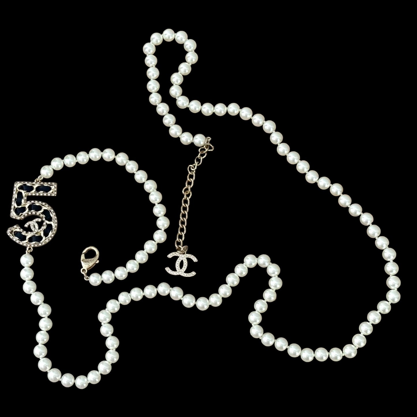 Chanel Knotted Pearl No.5 CC Sweater NecklaceIndulge in this gorgeous necklace adorned with a hand knotted pearl, Number 5 Chanel perfume charm, and sparkling crystals. The playful CC logo adds a touch of gold to the elegant black leather. Perfect for add My Mama Found What 