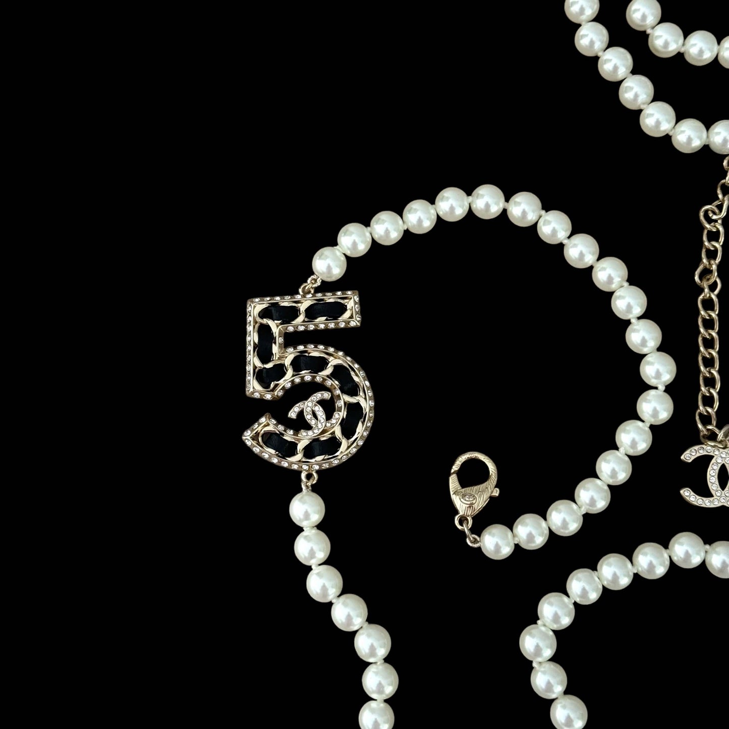 Chanel Knotted Pearl No.5 CC Sweater NecklaceIndulge in this gorgeous necklace adorned with a hand knotted pearl, Number 5 Chanel perfume charm, and sparkling crystals. The playful CC logo adds a touch of gold to the elegant black leather. Perfect for add My Mama Found What 