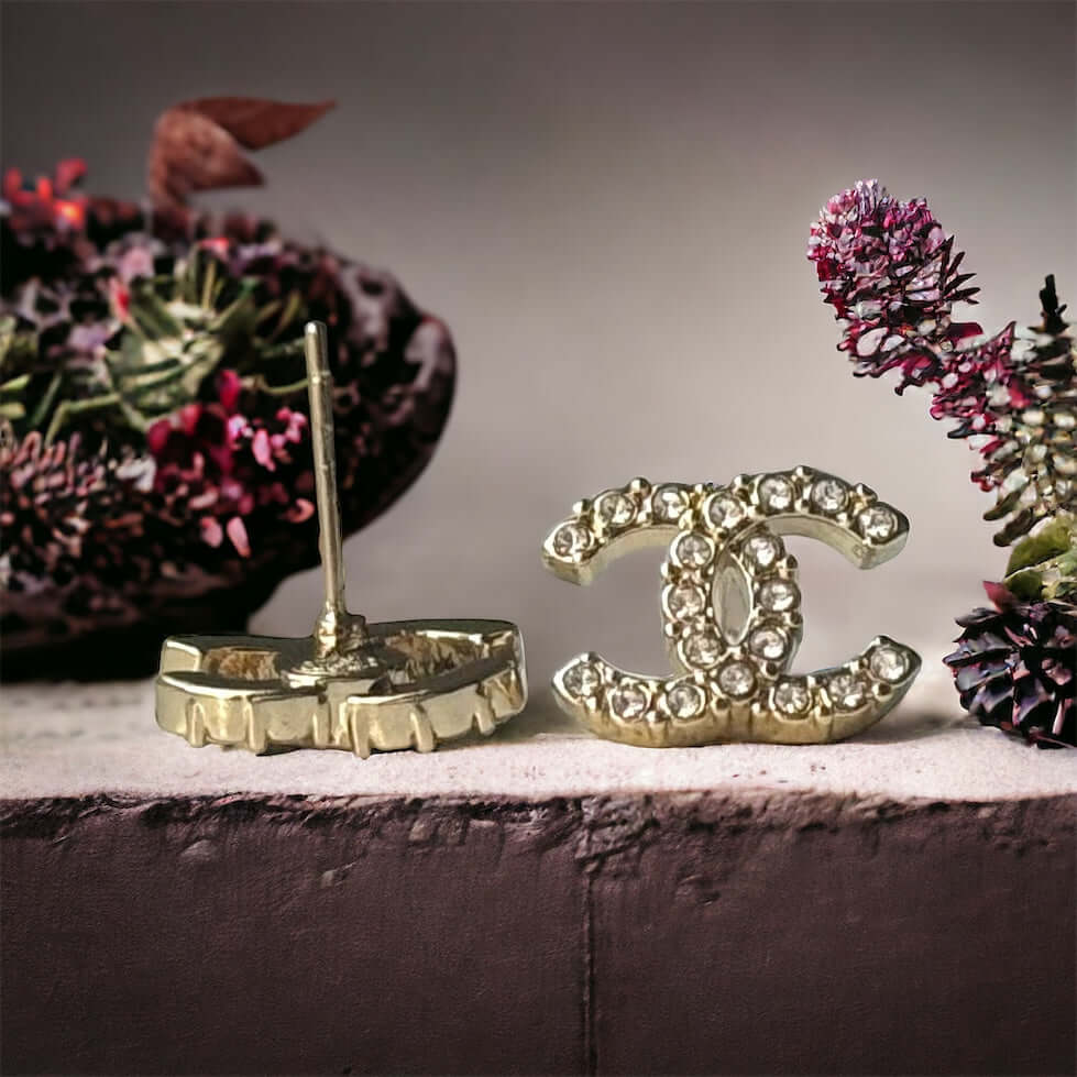 Chanel Lighter Gold Smaller Double C with round clear crystals earringsAccessorize with these lightweight Chanel Gold Double C earrings, featuring clear round crystals that add subtle sparkle to any outfit. Versatile for any occasion, these elegant earrin