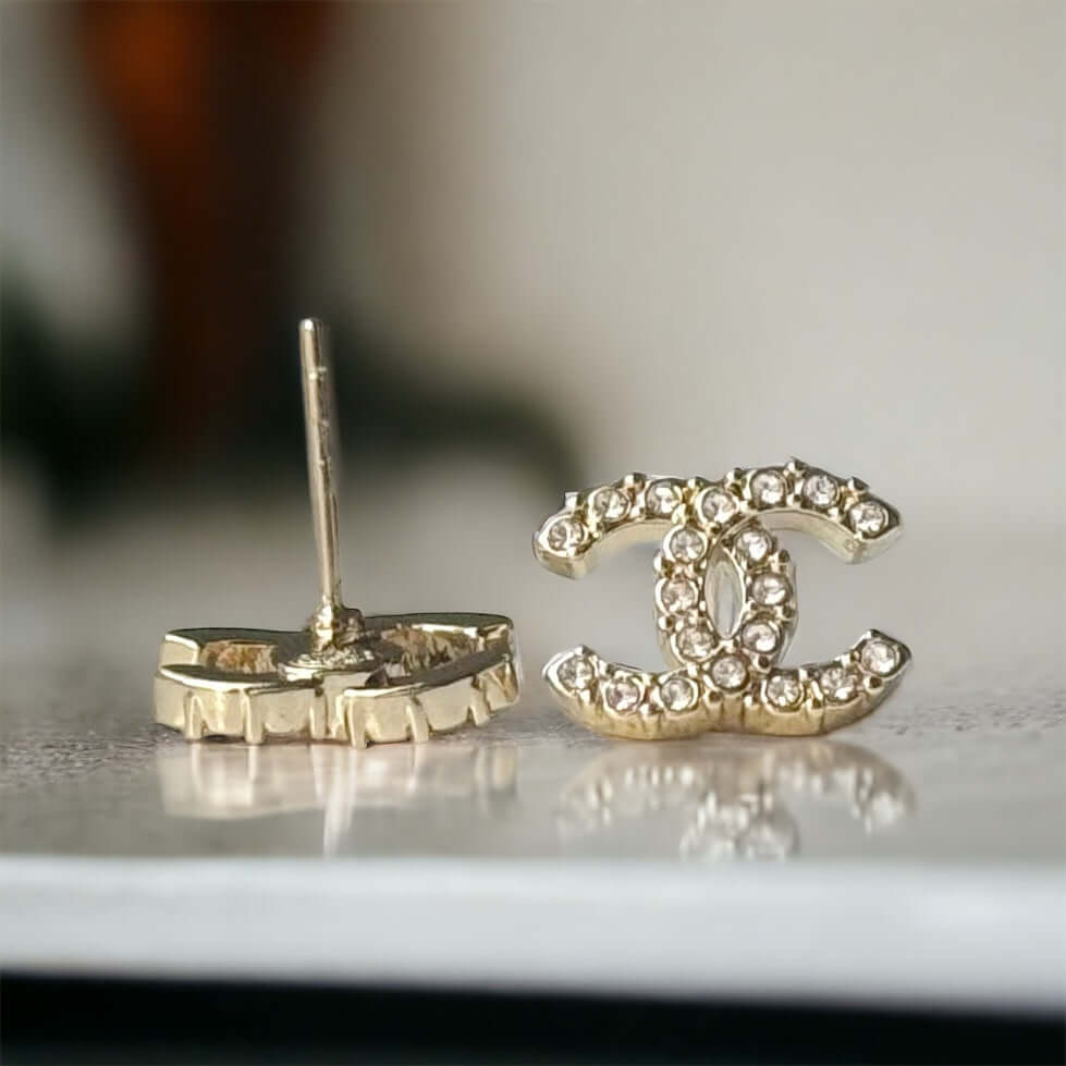 Chanel Lighter Gold Smaller Double C with round clear crystals earringsAccessorize with these lightweight Chanel Gold Double C earrings, featuring clear round crystals that add subtle sparkle to any outfit. Versatile for any occasion, these elegant earrin My Mama Found What 