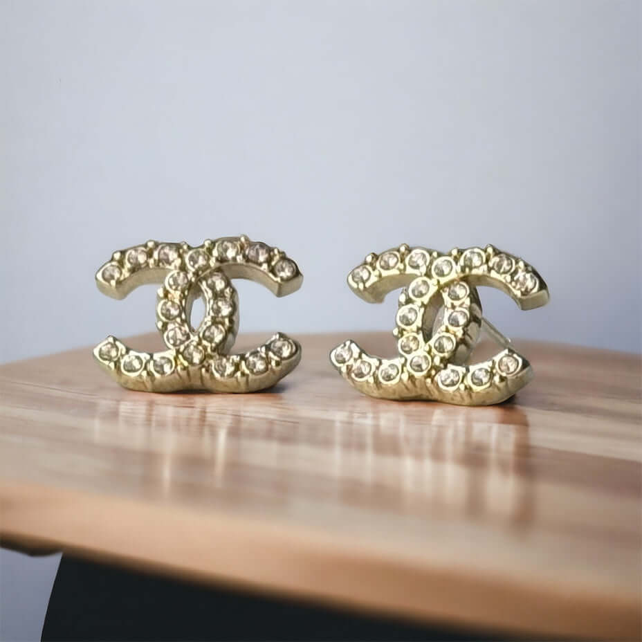 Chanel Lighter Gold Smaller Double C with round clear crystals earringsAccessorize with these lightweight Chanel Gold Double C earrings, featuring clear round crystals that add subtle sparkle to any outfit. Versatile for any occasion, these elegant earrin My Mama Found What 