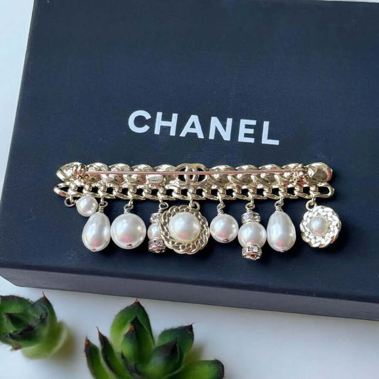 Chanel Rare Lighter Gold Long with Various Dangling Charms Brooch Pin 21 PIntroducing an elegant and rare brooch from Chanel, the Rare Lighter Gold Long Brooch with Various Dangling Charms! Accented with faux pearls and crystals, this brooch features a mi My Mama Found What 