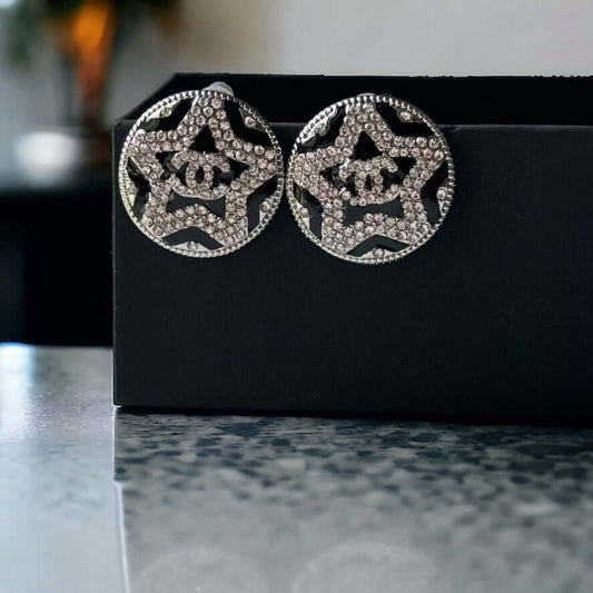 Chanel Round Silver & Black Double C with a Star Pattern Post EarringsBe daring and bold with these Chanel Round Silver & Black Double C Post Earrings. With a striking star pattern and sparkling crystals, these earrings will surely turn heads and make a s My Mama Found What 