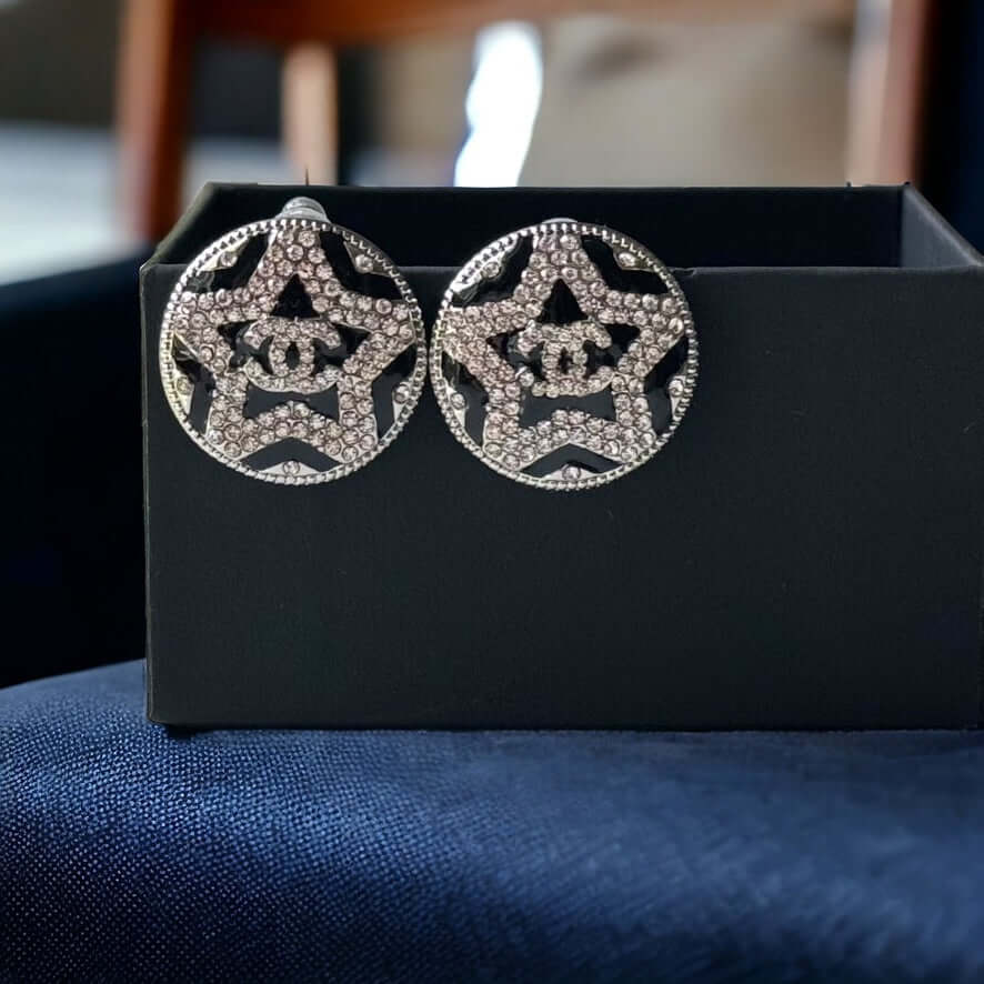 Chanel Round Silver & Black Double C with a Star Pattern Post EarringsBe daring and bold with these Chanel Round Silver & Black Double C Post Earrings. With a striking star pattern and sparkling crystals, these earrings will surely turn heads and make a s My Mama Found What 