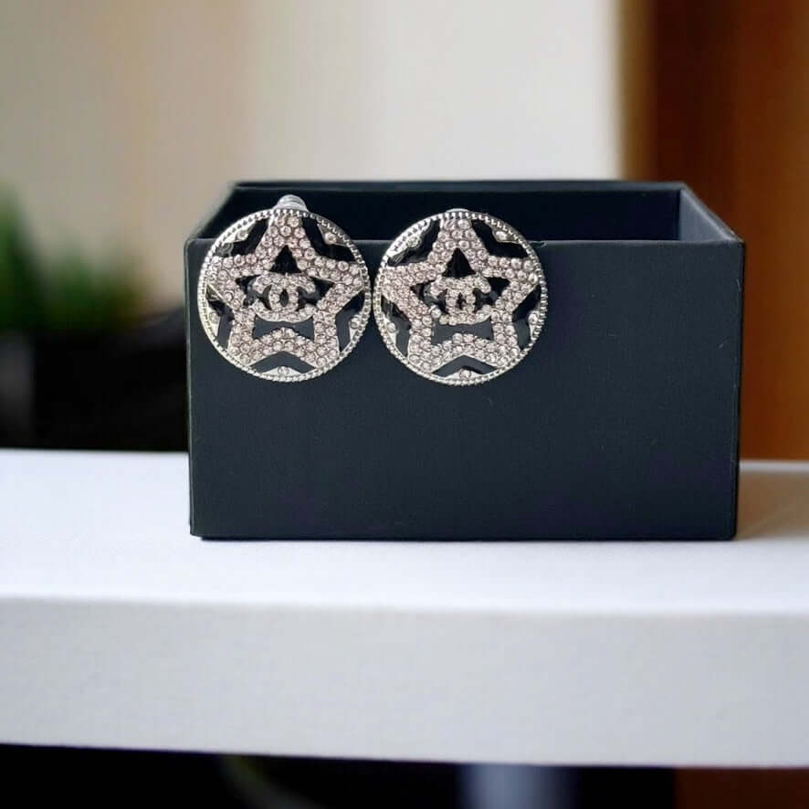 Chanel Round Silver & Black Double C with a Star Pattern Post EarringsBe daring and bold with these Chanel Round Silver & Black Double C Post Earrings. With a striking star pattern and sparkling crystals, these earrings will surely turn heads and make a s