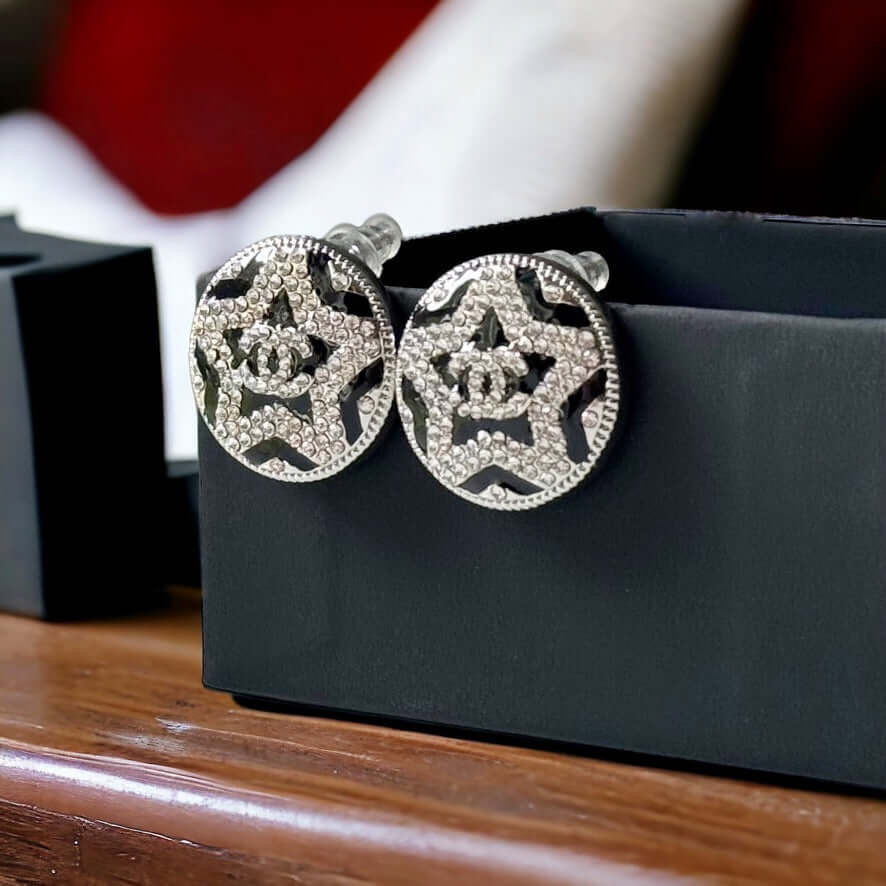 Chanel Round Silver & Black Double C with a Star Pattern Post EarringsBe daring and bold with these Chanel Round Silver & Black Double C Post Earrings. With a striking star pattern and sparkling crystals, these earrings will surely turn heads and make a s My Mama Found What 