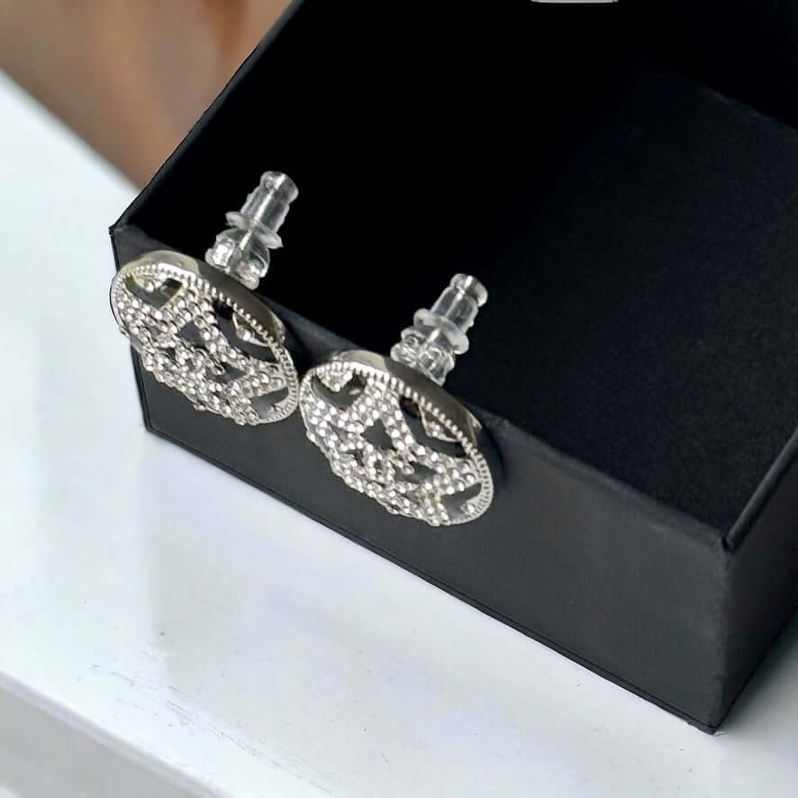 Chanel Round Silver & Black Double C with a Star Pattern Post EarringsBe daring and bold with these Chanel Round Silver & Black Double C Post Earrings. With a striking star pattern and sparkling crystals, these earrings will surely turn heads and make a s