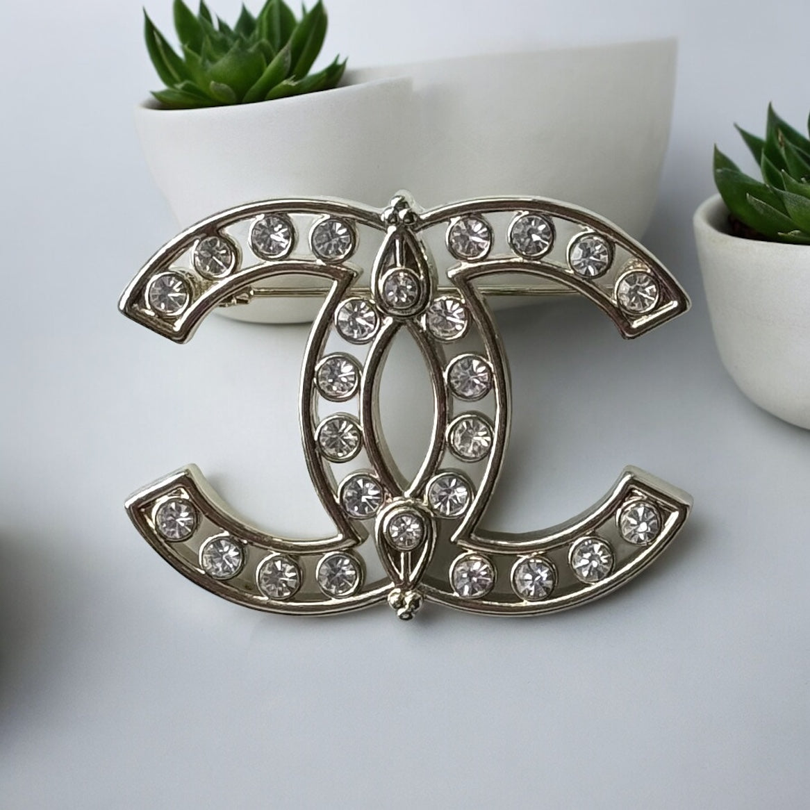 Chanel Strass Double C Cut Out with Clear Crystals Brooch Pin B23 ATransform any outfit into a statement piece with the Chanel Gold Double C brooch. Made in Italy, this brooch features bright clear crystals in Coco Chanel's signature cut-out design. Perfe