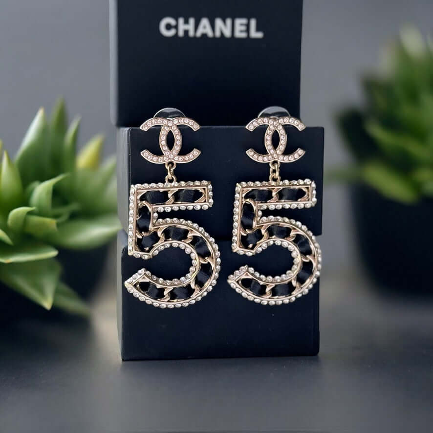 Chanel Gold Number 5 Big Dangle CC EarringsMake a statement with these iconic Chanel Gold Number 5 Big Dangle CC Earrings. The perfect addition to any outfit, these trendy and luxurious earrings feature gold plating, clear crystals, and a bold Chanel No.