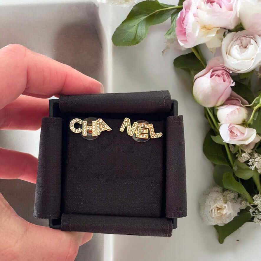 Chanel 14K Gold Name Cut-Out w/ clear crystals earringsAdd a touch of elegance and playfulness to your outfit with these Chanel 14K Gold Cut-Out Name earrings. The clear crystals add a subtle sparkle, making them perfect for any occasion. Their smaller si