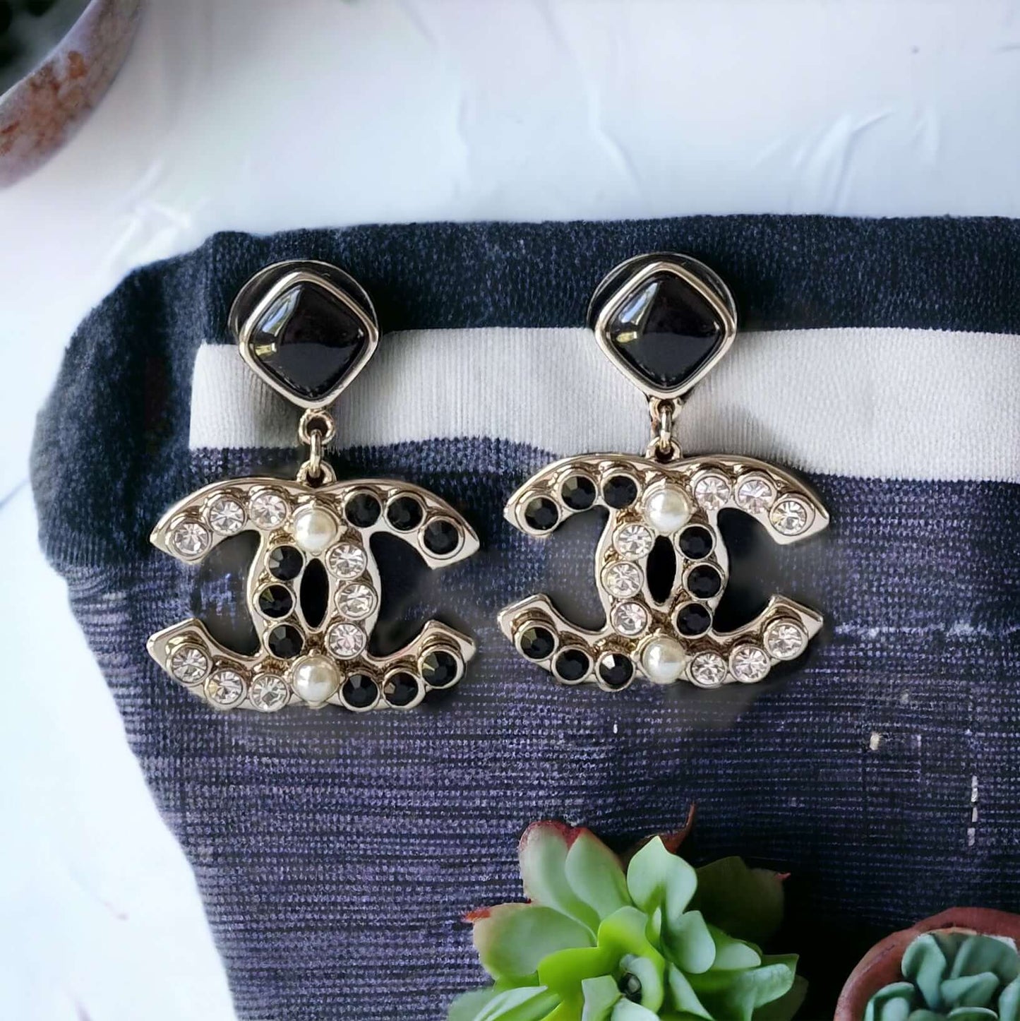 Chanel Gold Setting Double C Dangle Post EarringsAdd a touch of glamour to your outfit with these gold Chanel earrings featuring a double C design. The dangle style, adorned with faux pearls, clear crystals, and black stones, will catch everyone's eye wit