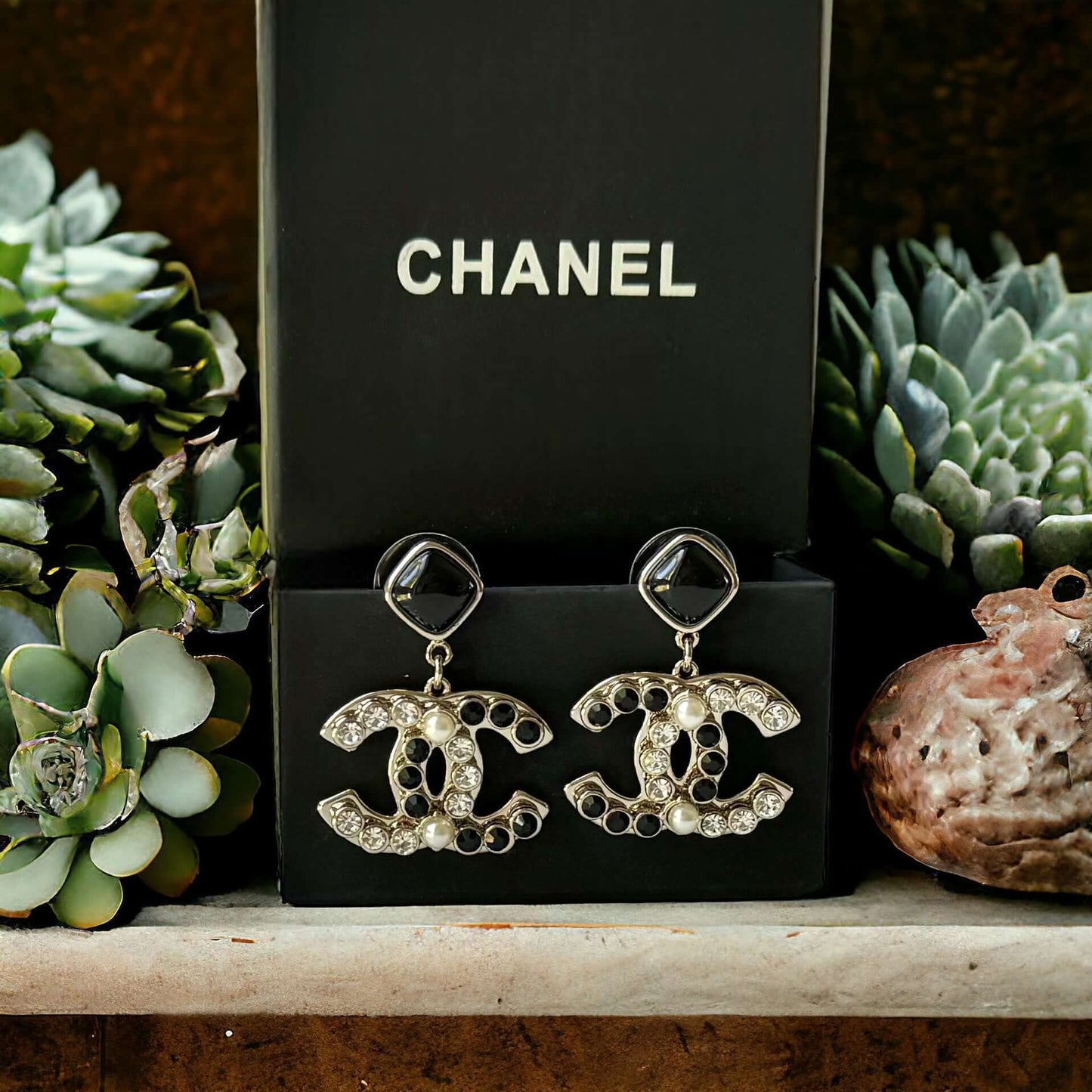 Chanel Gold Setting Double C Dangle Post EarringsAdd a touch of glamour to your outfit with these gold Chanel earrings featuring a double C design. The dangle style, adorned with faux pearls, clear crystals, and black stones, will catch everyone's eye wit