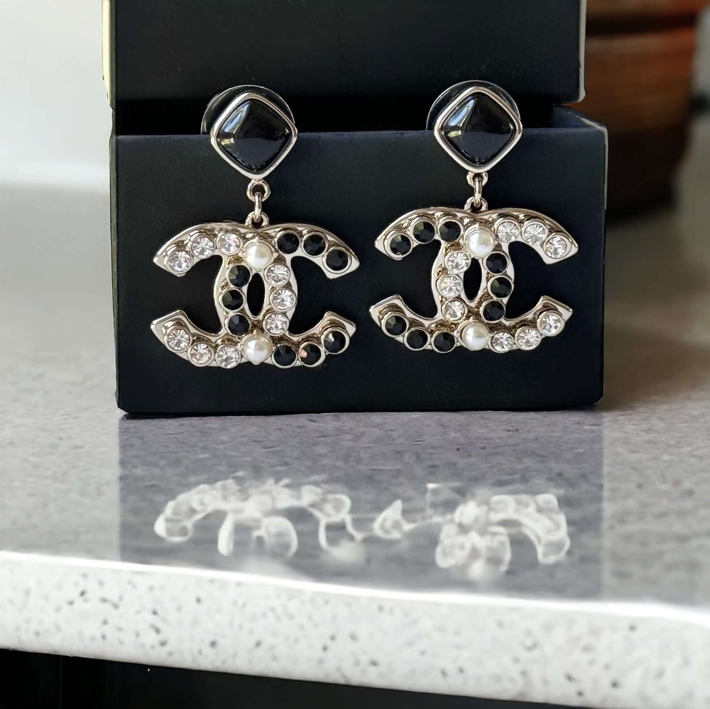 Chanel Gold Setting Double C Dangle Post EarringsAdd a touch of glamour to your outfit with these gold Chanel earrings featuring a double C design. The dangle style, adorned with faux pearls, clear crystals, and black stones, will catch everyone's eye wit