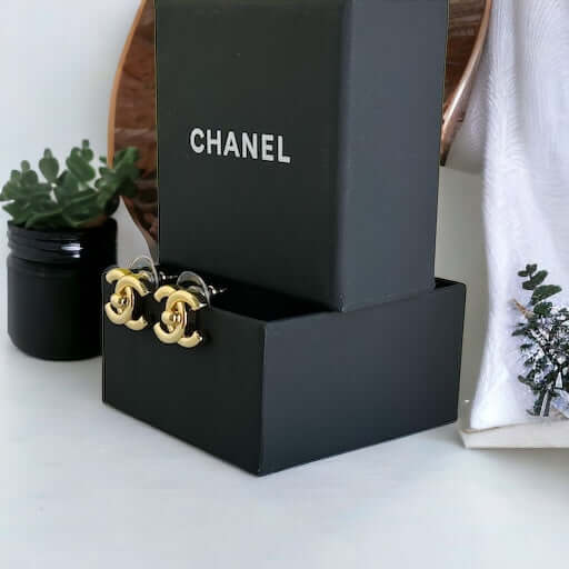 Chanel Gold Double C Lock Post EarringsIndulge in sophistication with our Chanel Gold Double C Lock Post Earrings. Crafted in 14K gold tone, these iconic and elegant earrings are the epitome of luxury. The double C lock style, made in Italy, adds a touch