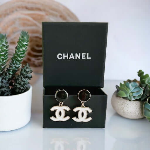 Chanel New Gold Black & White Double C Dangle Post EarringsExperience the latest trend with these Chanel New Gold Black & White Double C Dangle Post Earrings. The sophisticated black post earrings are complemented by the elegant and minimalistic white dou