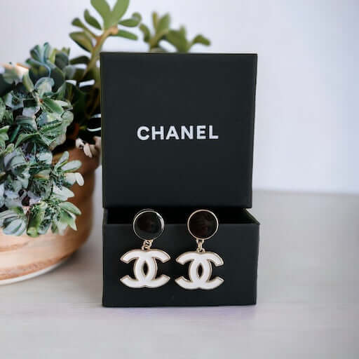 Chanel New Gold Black & White Double C Dangle Post EarringsExperience the latest trend with these Chanel New Gold Black & White Double C Dangle Post Earrings. The sophisticated black post earrings are complemented by the elegant and minimalistic white dou