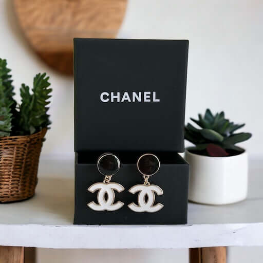 Chanel New Gold Black & White Double C Dangle Post EarringsExperience the latest trend with these Chanel New Gold Black & White Double C Dangle Post Earrings. The sophisticated black post earrings are complemented by the elegant and minimalistic white dou