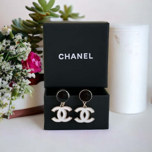 Chanel New Gold Black & White Double C Dangle Post EarringsExperience the latest trend with these Chanel New Gold Black & White Double C Dangle Post Earrings. The sophisticated black post earrings are complemented by the elegant and minimalistic white dou